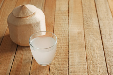 Glass of coconut milk and nuts on wooden table