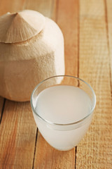Glass of coconut milk and nuts on wooden table