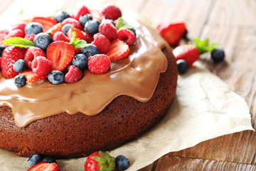 Homemade chocolate cake with berries on brown wooden table
