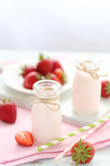 Strawberry yogurt in bottle on wooden table