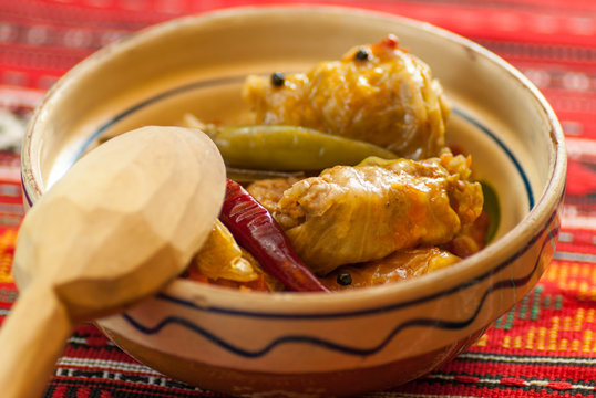 meat rolls sarmale in clay bowl with wooden spoon