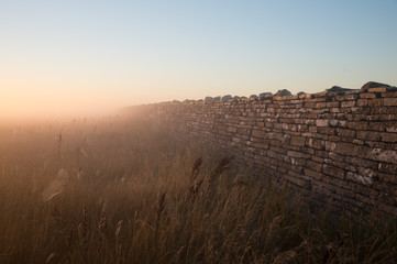 Stone wall in early morning mist