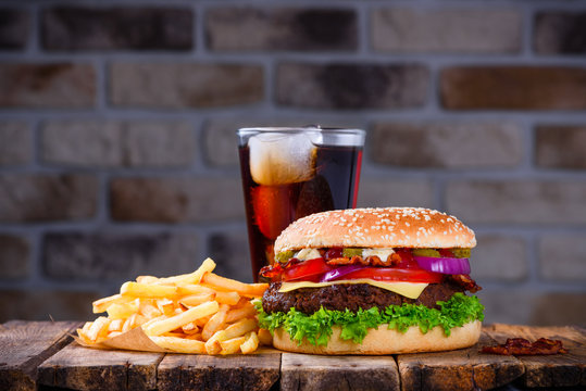Hamburger with french fries and cola on wooden table