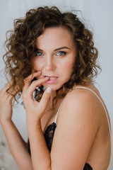 Obraz premium Sexy woman in bed in the morning showing her beautiful body. She doesn't wants to wake up. Awaken with natural light in her bedroom and covered with the bed sheets.