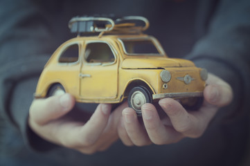 Manos de un niño sujetando un coche de juguete