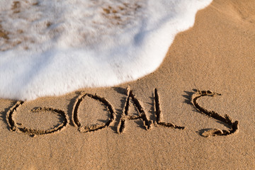 word goals in the sand of a beach