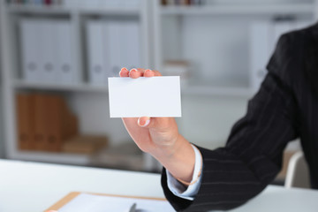 Businesswoman holding blank visit card ,sitting on the desk