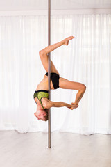 Young pole dancer in the studio