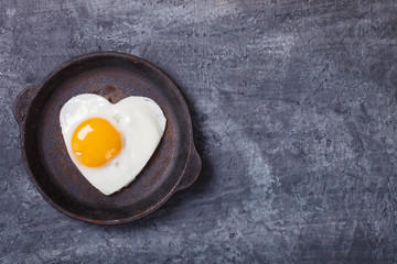 Fried egg in heart shape on the pan.Holiday Valentine's Day.Breakfast. Healthy Food.selective focus.