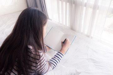 female hands holding pen and opened diary book