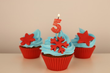 number 5 candle on red cupcake