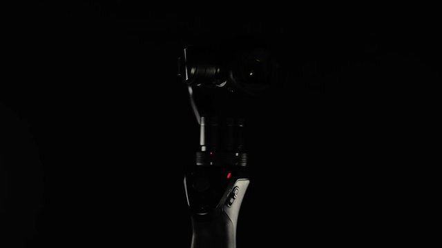 Portable video camera lens with electronic stabilizing system Close up footage. Camera on black background.