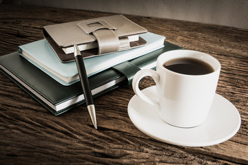 coffee cup and notebook on wooden table