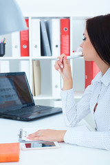 Beautiful young businesswoman working on a laptop in the office. Business, exchange market, job...