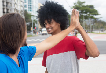 African american man give high five to a caucasian friend