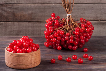viburnum berries in a bowl on  wooden background