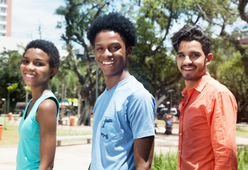Obraz premium Group of three happy latin american young adults in city