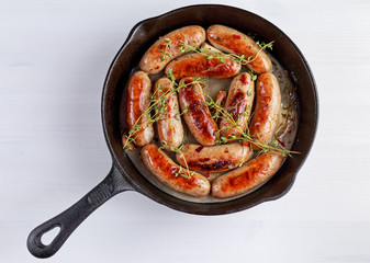 Home-made Pork Sausages in rustic pan with thyme