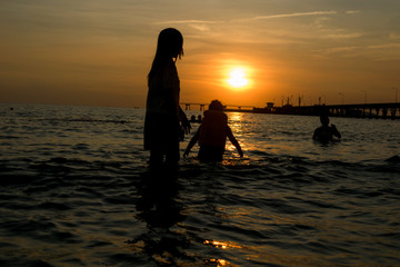 Fototapeta premium People walk ocean beach sunset