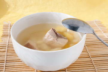 Spoon is on the plate with the fish soup  