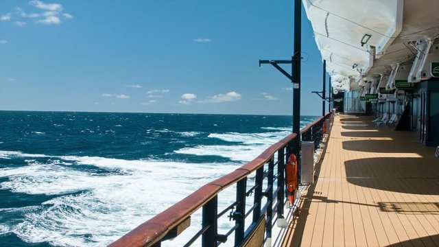 Cruise Ship Empty Open Deck while Cruising At Sea on a Sunny Day with Rough Water Breaking White Foam on the Blue Surface