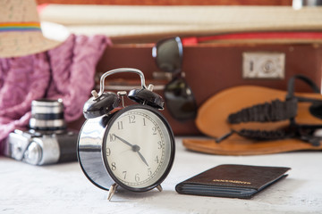 alarm clock, documents and things for a holiday in a suitcase, selective focus
