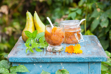 jam from a pear in a jar on a table in a garden, selective focus