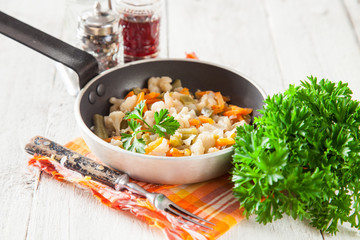 stewed vegetables in a frying pan on a table, selective focus