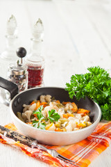 stewed vegetables in a frying pan on a table, selective focus