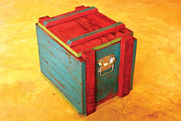 Vintage colorful wooden storage box on yellow concrete floor
