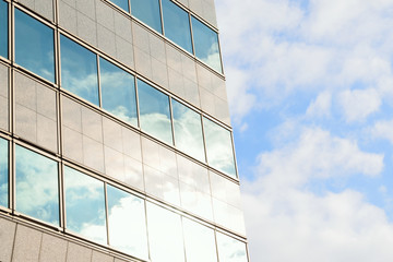 Fototapeta na wymiar Modern building with clouds & sunshine in horizontal frame
