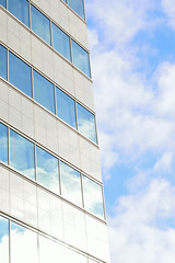 Fototapeta na wymiar Modern building with clouds & sunshine in vertical frame
