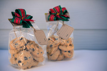 Chocolate cookies in bag on white wooden background.