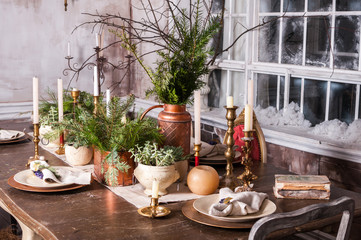 Dining table decorated for Christmas and evergreen centerpiece