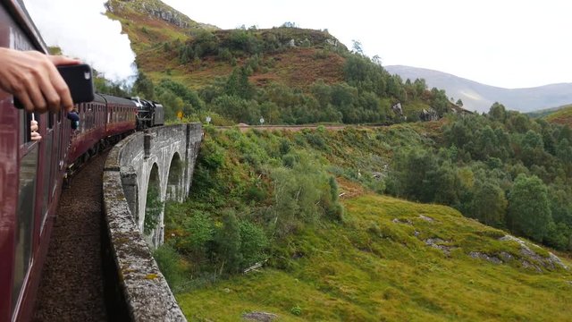 Glenfinnan Railway Viaduct in Scotland with the Jacobite steam train in Scotland, UK
