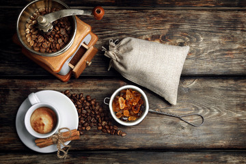 Cup of black coffee, the fried coffee grains, the manual coffee grinder and caramelized sugar