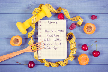 Vintage photo, New year resolutions written in notebook on board