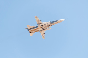 Sukhoi Su-24 (Fencer) supersonic all-weather attack bomber aircraft flies against blue sky background