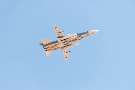 Sukhoi Su-24 (Fencer) supersonic all-weather attack bomber aircraft flies against blue sky background
