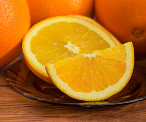 Slices of orange closeup on background of whole oranges