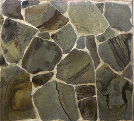 Wall made of black rough stone close-up