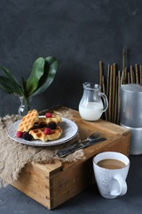 Breakfast waffles with fresh berries stacked on a plate