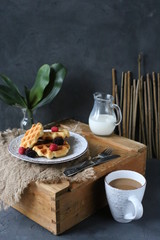 Breakfast waffles with fresh berries stacked on a plate