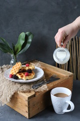 Breakfast waffles with fresh berries stacked on a plate