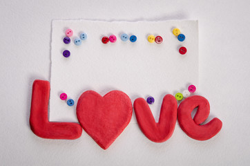 The word LOVE , empty card and colorfull buttons