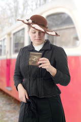 woman in  vintage costume 1900s, old train background