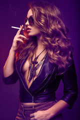 Portrait of elegant blonde woman in glasses smoking a cigarette