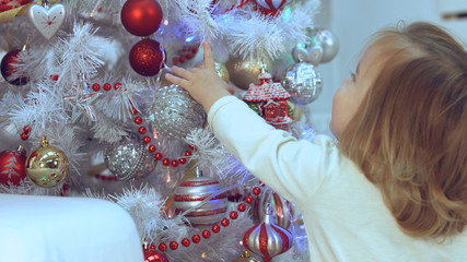 Little girl looks at the bright Christmas decorations
