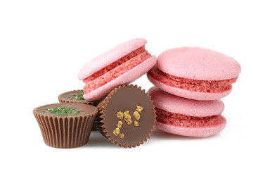 Chocolate candies with pink macaroon on a white background isolated.