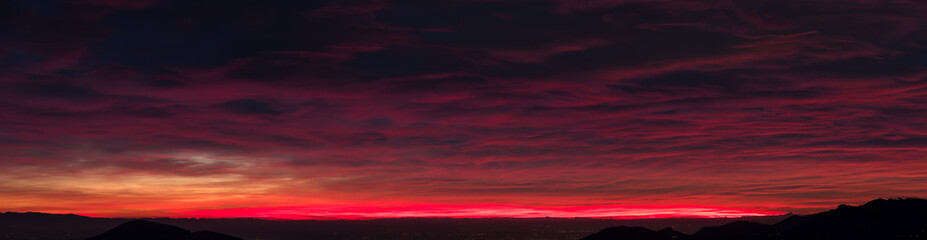 Fiery sunset from mountain pick in a cloudy evening. Fall season. Orobie mountains. Italian Alps.